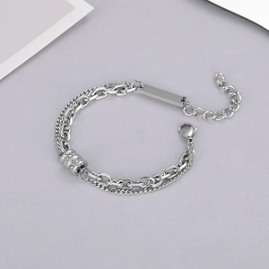 Close-up of double-layer titanium steel bracelet with pavé-set cylinder and ID tag