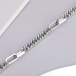 Macro shot of a chunky hip-hop Cuban link chain mixed with sleek paperclip style links