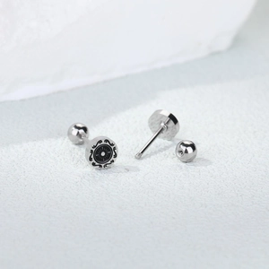 Retro stainless steel rudder stud earring with screw back on stone background
