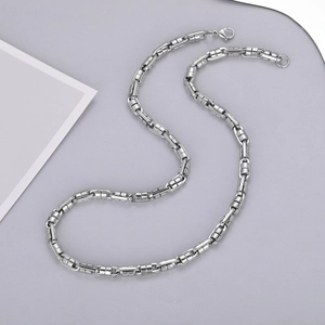 Macro detail of industrial style silver bamboo link chain necklace with lobster clasp
