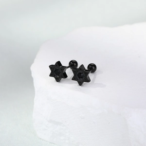 Detailed macro of black hexagram ear studs with inset stone and secure ball-back closure