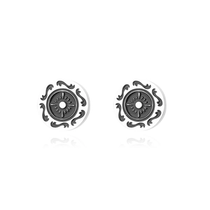Macro detail of retro titanium steel stud earrings featuring black sunburst pattern