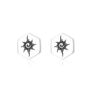 Macro detail of hexagonal stainless steel stud earrings with black sun spiral engraving