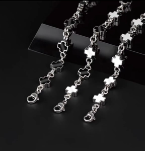 Detailed shot of titanium steel cross bracelet with black and white enamel inlays