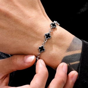 Macro shot of silver titanium steel link bracelet with black gothic cross charms for unisex