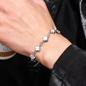 Detailed close-up of a silver stainless steel cross bracelet with white enamel inlays