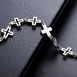 Titanium steel hollow cross bracelet with silver finish links on leather background