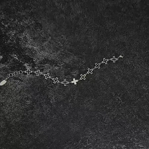 Detailed close-up of hollow cross links and lobster clasp on silver stainless steel bracelet
