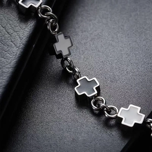 Macro detail of black and white cross link bracelet in polished stainless steel