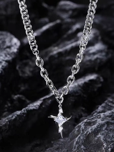 Detail of silver stainless steel chain necklace with star-cross pendant and crystals