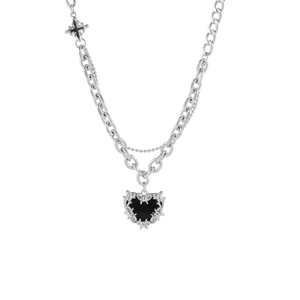 Détail du collier gothique Y2K avec double chaîne argentée et pendentif cœur épines