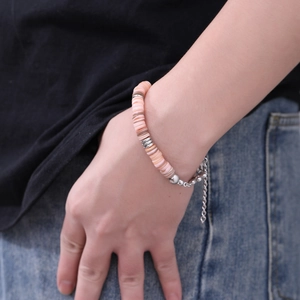 Dettaglio di un bracciale di perline rosa in acciaio inossidabile con catena regolabile