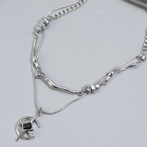 Détail du collier argenté double épaisseur avec croissant de lune et pierre noire