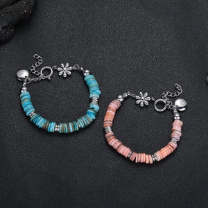 Bracciali boho con perle di pietra e ciondoli a fiore d'argento su sfondo nero