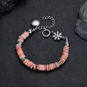 Dettaglio del bracciale di perline con pietre rosa, ciondolo a fiore in argento e chiusura