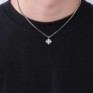 Dettaglio del ciondolo a croce fleur-de-lis hip hop con zirconi e catena a scatola