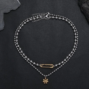 Détail du collier à double chaîne à billes avec pendentif marguerite dorée et épingle