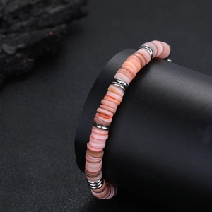 Dettaglio di perline in conchiglia rosa e distanziatori in argento su bracciale retrò