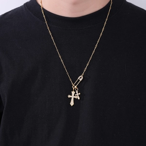 Detail der goldenen Doppelkreuz-Nadel-Halskette mit Zirkonia auf schwarzem Shirt