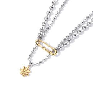 Détail du collier à double chaîne à billes argentées avec épingle et fleur dorée