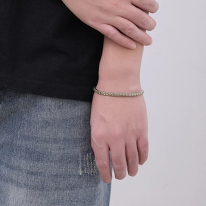 Vista dettagliata di un bracciale tennis in argento con zirconi verdi indossato al polso