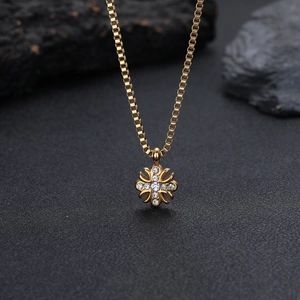 Dettaglio del ciondolo a croce fleur-de-lis dorata hiphop con pietre di zirconia cubica