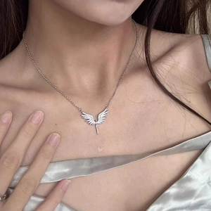 Détail du collier ailes d'ange en argent avec zircons porté sur un cou féminin