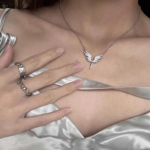 Détail du collier aile d'ange en argent avec cristaux et bagues assorties en métal