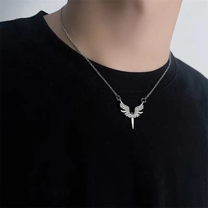 Détail macro du pendentif aile d'ange et épée argentée avec zircons étincelants