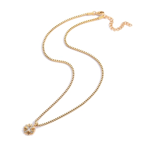 Dettaglio della collana a catena box dorata con ciondolo a croce di fiori ghiacciati