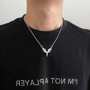 Détail du collier ailes d'ange en argent avec strass blancs porté par un mannequin homme