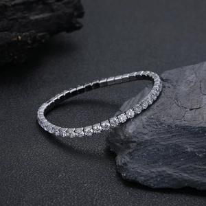 Dettaglio ravvicinato di un bracciale tennis con zirconi bianchi su una roccia nera scura
