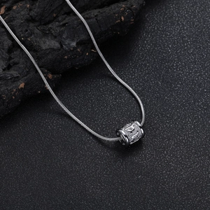 Détail d'un collier chaîne serpent en argent avec pendentif cylindrique gaufré