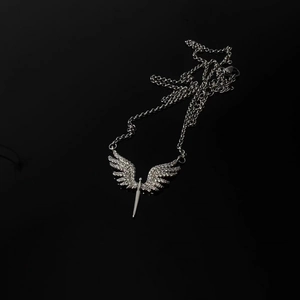 Détails du collier pendentif ailes d'ange et épée argentée avec zircons étincelants