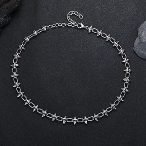 Détail d'un collier de style punk en acier titane avec rivets et fermoir mousqueton poli