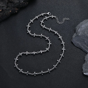 Dettaglio del bracciale in acciaio al titanio argento con maglie a trifoglio e moschettone