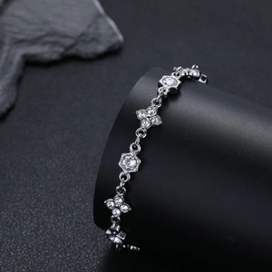 Bracciale quadrifoglio argento con zirconi brillanti esposto su un supporto nero