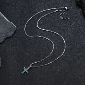 Dettaglio della catena box argento con ciondolo a croce in cristallo blu e chiusura a moschettone