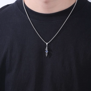 Macro view of geometric prism pendant with blue zircon stone on silver box chain
