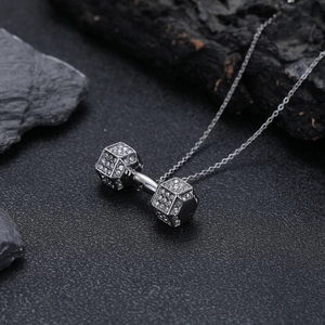 Collier haltère argenté avec cristaux étincelants sur fond de pierre pour fans de fitness