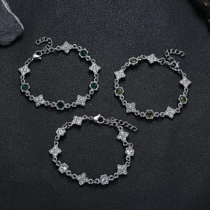 Eleganti bracciali a quadrifoglio con zirconi colorati su uno sfondo di roccia nera