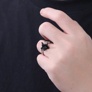 Macro shot of a gothic black flower ring with layered petals on a silver band