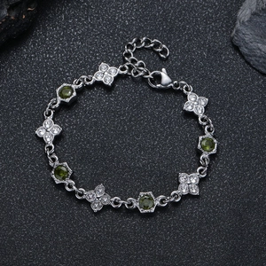 Dettaglio del bracciale a quadrifoglio con pietre verdi e zirconi su pietra nera