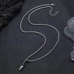 Close-up of geometric spearhead pendant with blue zircon on steel Venetian chain