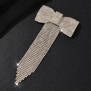 Pince à cheveux papillon dorée élégante avec glands en strass sur fond de cuir noir texturé