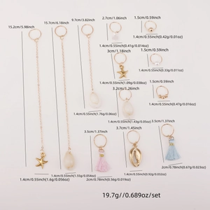 Detailed view of 10-piece gold bohemian hair rings with shells and tassels on pink background