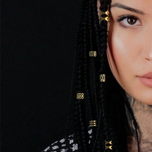 Golden dreadlock accessories set featuring hollow rings on braided hair with bohemian style