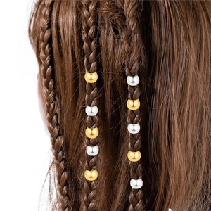 Détail de perles rondes dorées et argentées pour dreadlocks et coiffures tressées