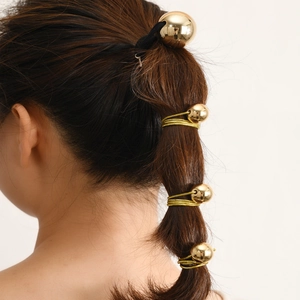 Élastiques à cheveux avec sphères dorées sur cheveux châtains pour un style élégant