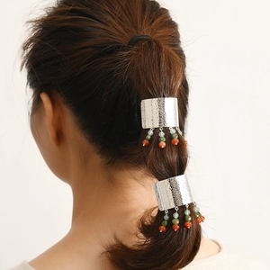 Detail von böhmischen Haarmanschetten mit gehämmertem Metall und Glasperlenquasten